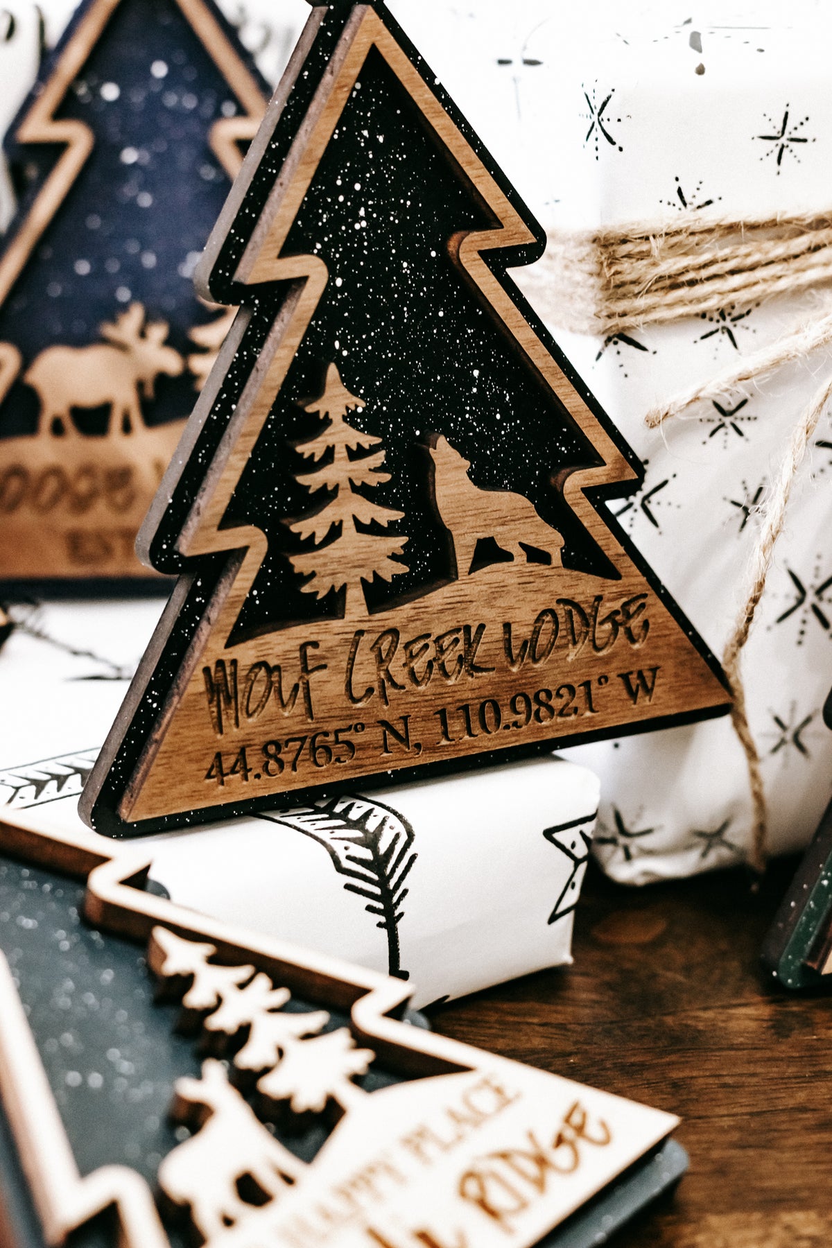 Close-up of a hanging tree-shaped ornament with pine and dog silhouette