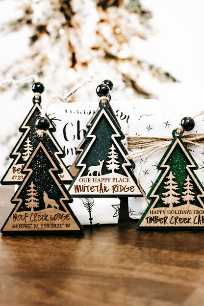 Hanging tree-shaped ornaments with cabin sign wording and small star accents