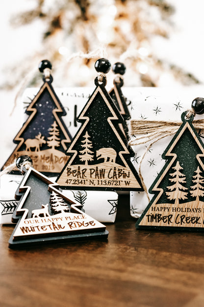 Assorted wooden tree ornaments with hanging beads, dark green centers, gold edges, twig accents.