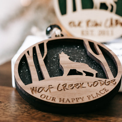 Round wooden Christmas ornament close-up with deer silhouette, dark center, and script text
