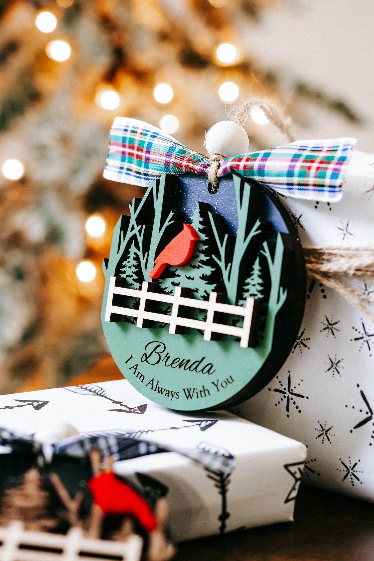 Cardinal memorial keepsake ornament with plaid bow, evergreen trees and fence; Brenda