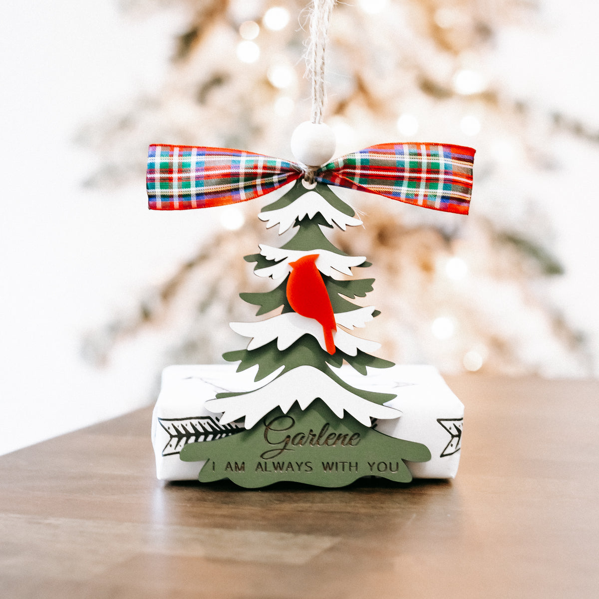 Cardinal memorial Christmas tree ornament with plaid bow and layered evergreen cutouts