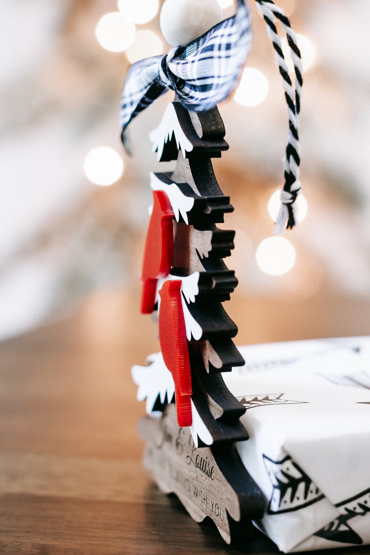 Hanging Christmas ornament showing side of layered tree cutouts and red cardinal figure