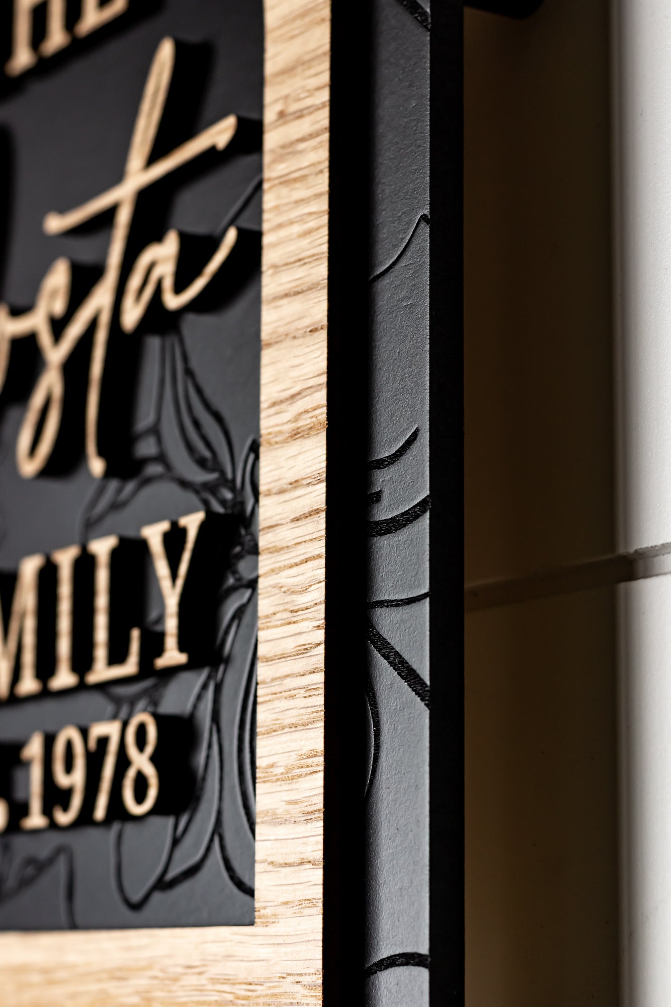 Close-up of framed arch sign edge with light wood frame and black panel