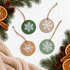 Set of round wooden snowflake ornaments with green and natural wood, white cutouts, twine hangers