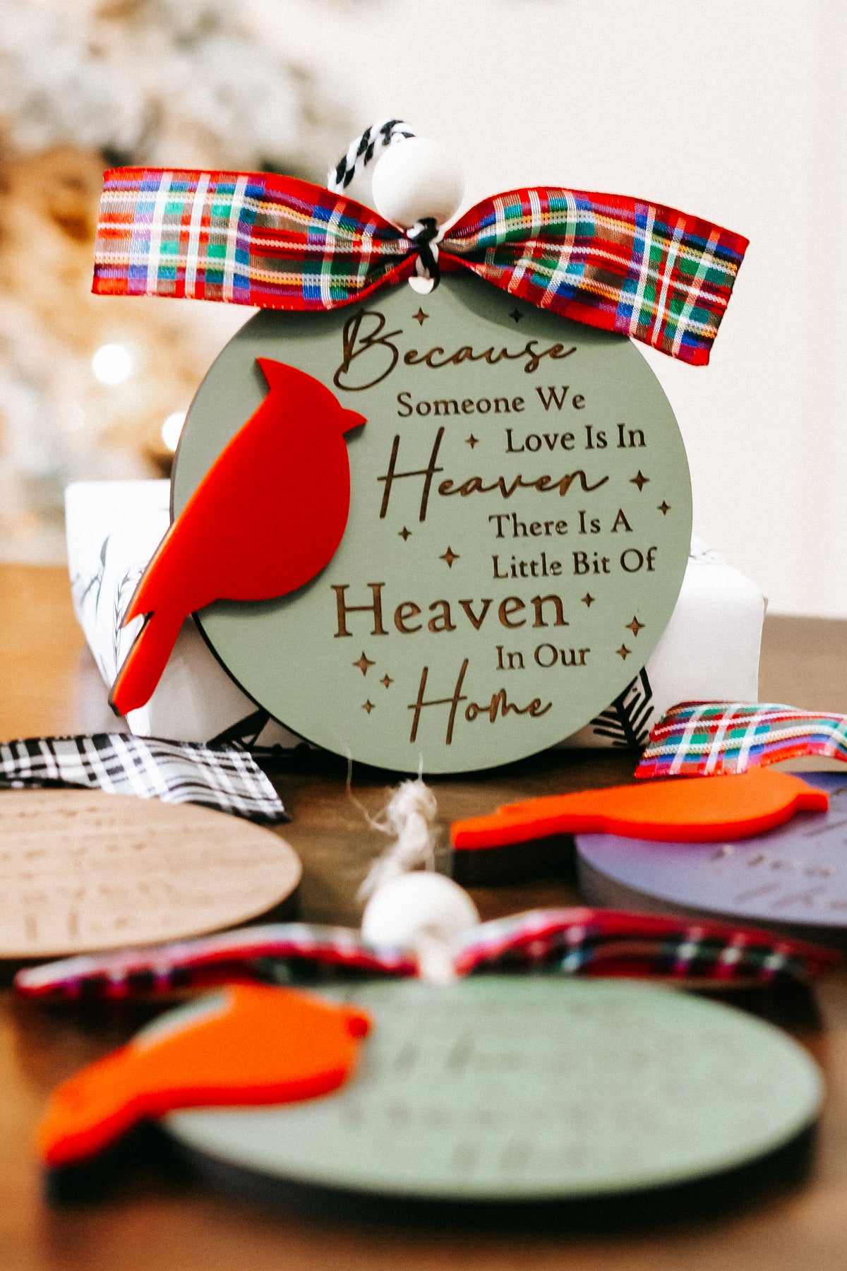 Cardinal memorial ornament with green oval tag, red cardinal, plaid ribbon bow, hanging bead