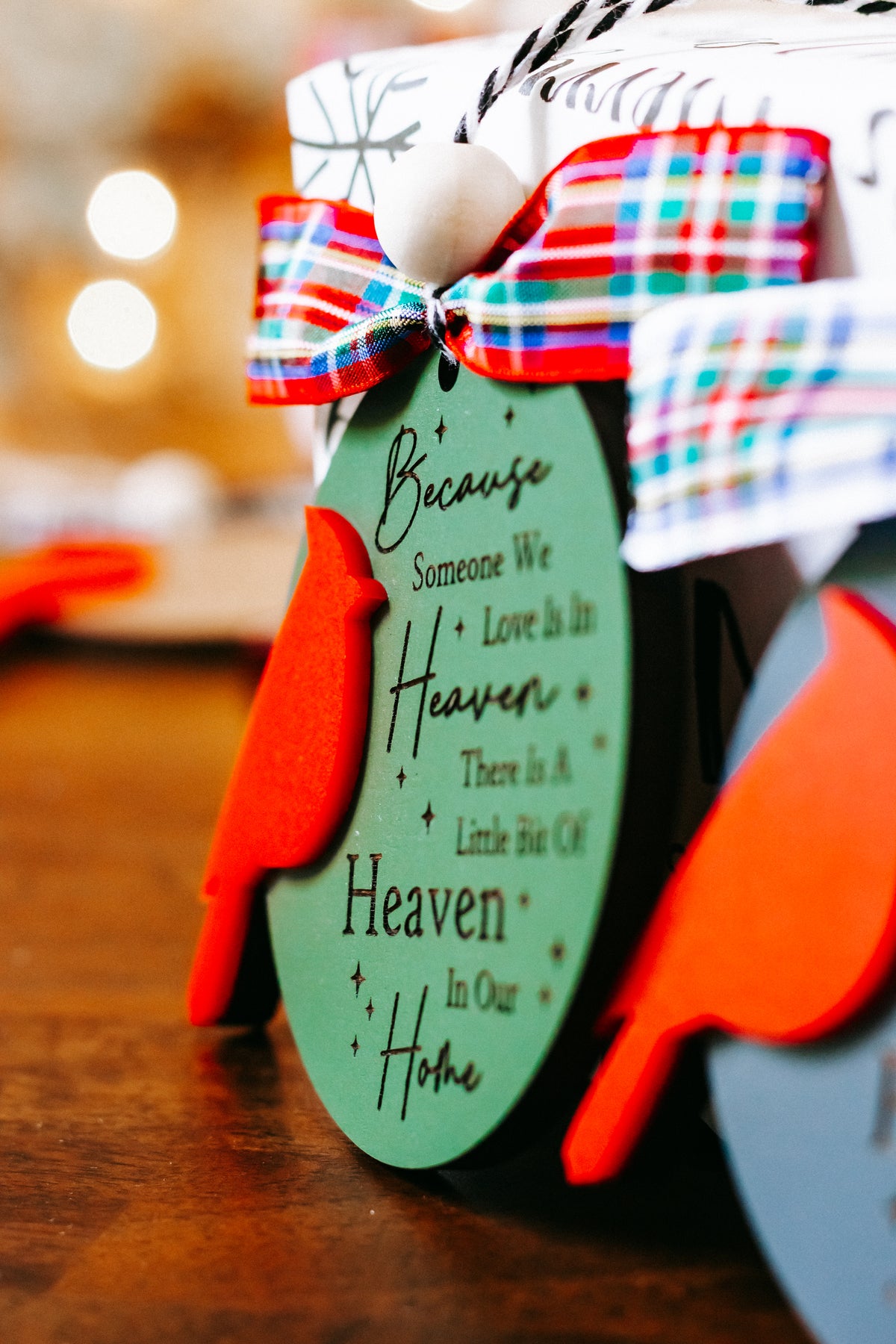Cardinal memorial ornament with green oval tag, red cardinal, plaid ribbon bow, hanging bead