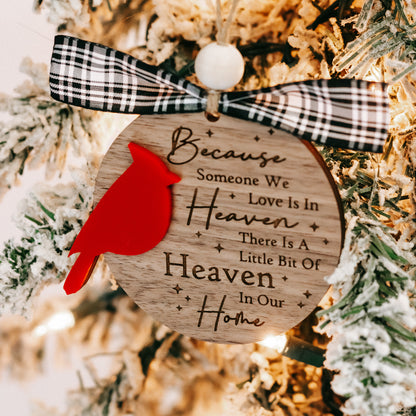 Cardinal memorial ornament hanging on pine branches with black-and-white plaid bow