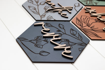 Close-up of hexagon wooden wall art with engraved floral linework and cutout script