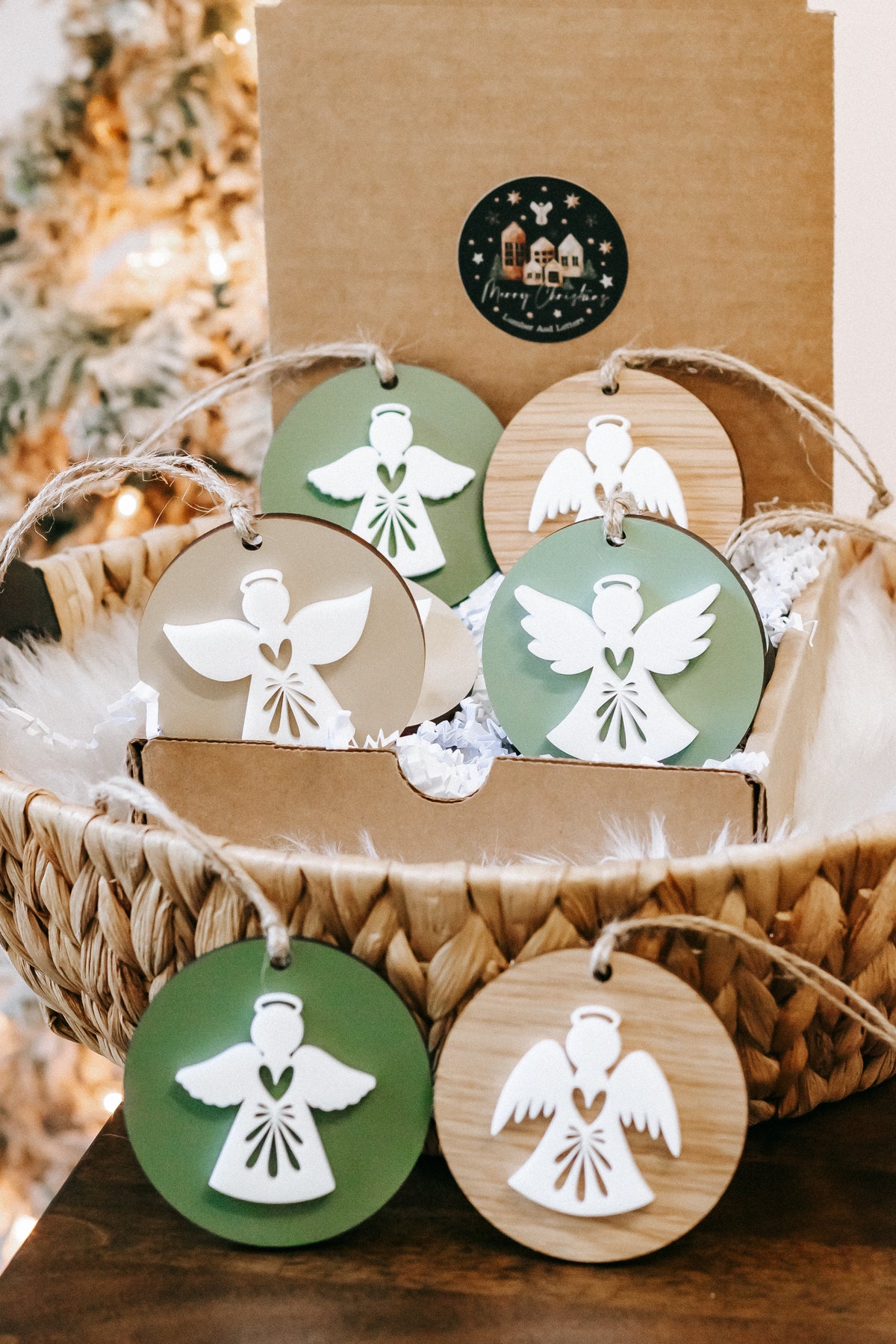 Layered angel ornaments: green and wood round discs with white angel cutouts and twine loops