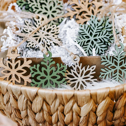 Mini wooden snowflake ornaments on twine with green inlays and natural wood edges