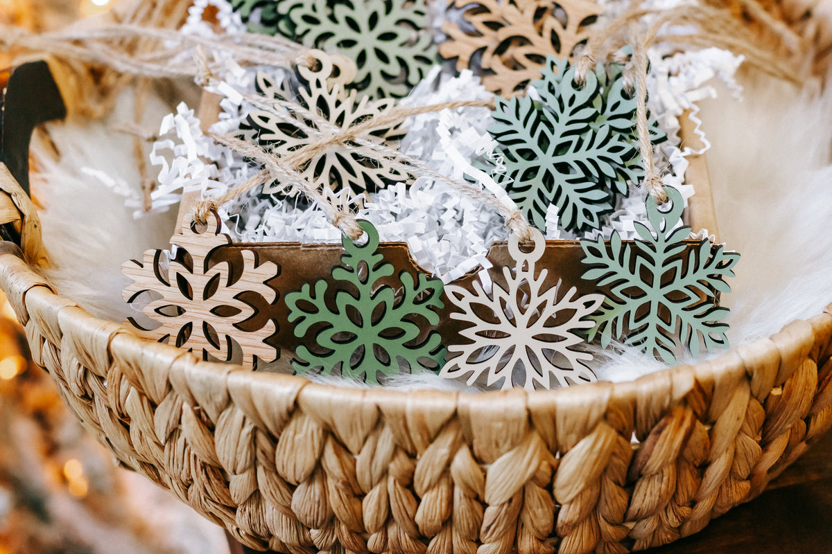 Mini wooden snowflake ornament set with green inlays and twine hanging loops