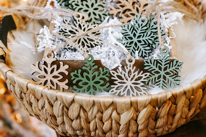 Mini wooden snowflake ornament set with green inlays and twine hanging loops