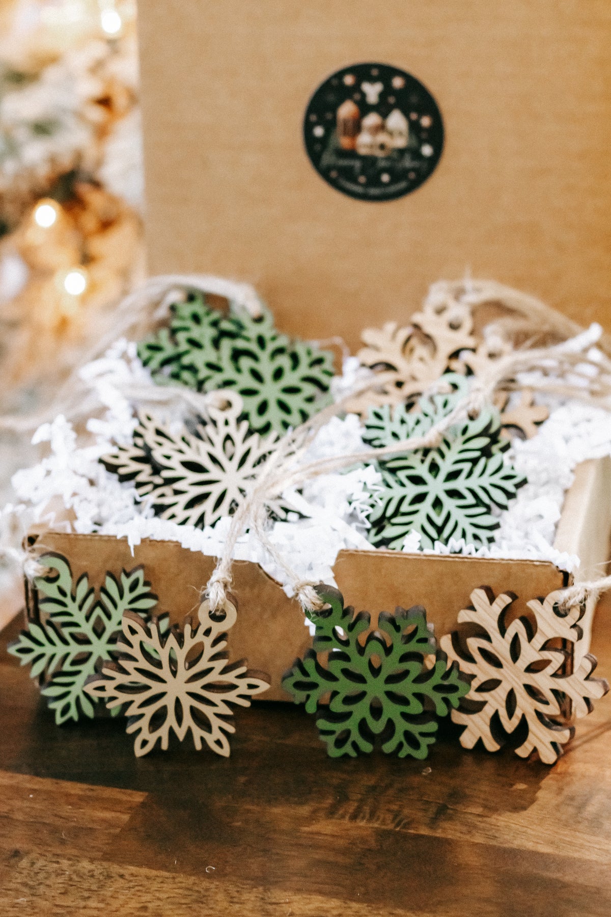 Small wooden snowflake ornaments with green accents and hanging loops, set of mini pieces.