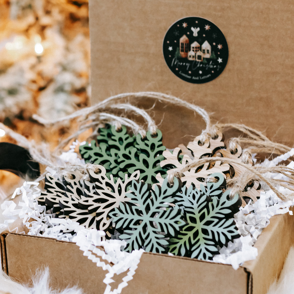Set of mini wooden snowflake ornaments on twine, with green and natural wood layers