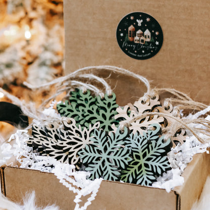 Set of mini wooden snowflake ornaments on twine, with green and natural wood layers