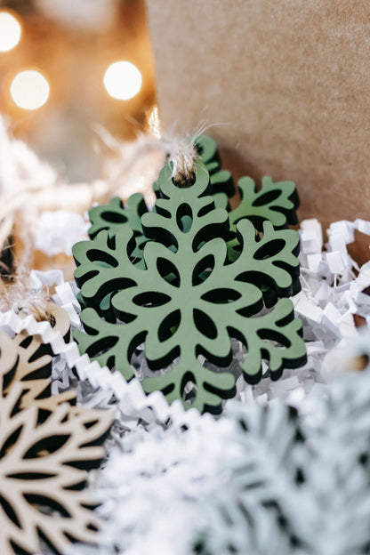 Mini wooden snowflake ornament with green center and twine loop