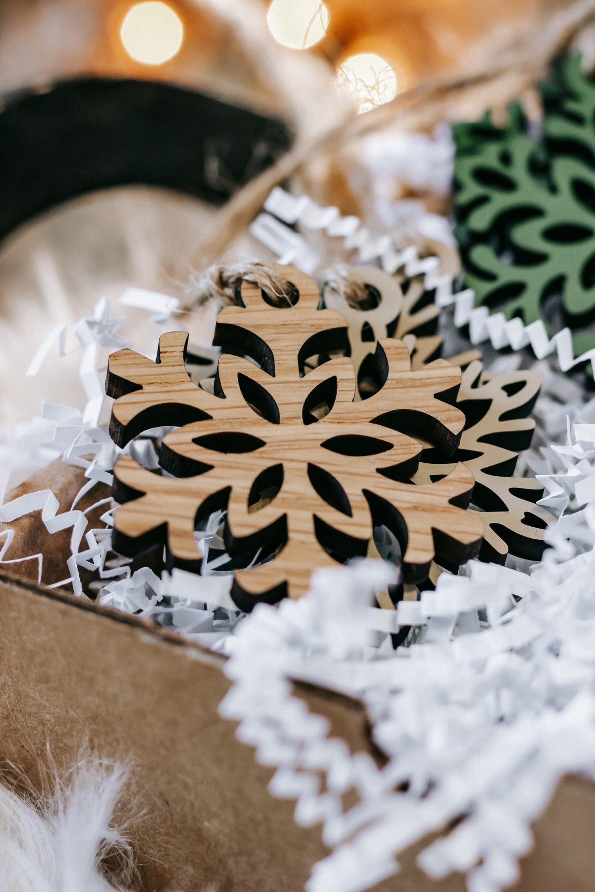 Mini wooden snowflake ornament with natural wood cutout and twine loop