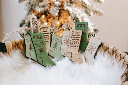 Set of engraved wooden stocking ornaments in green and cream with seasonal pattern details