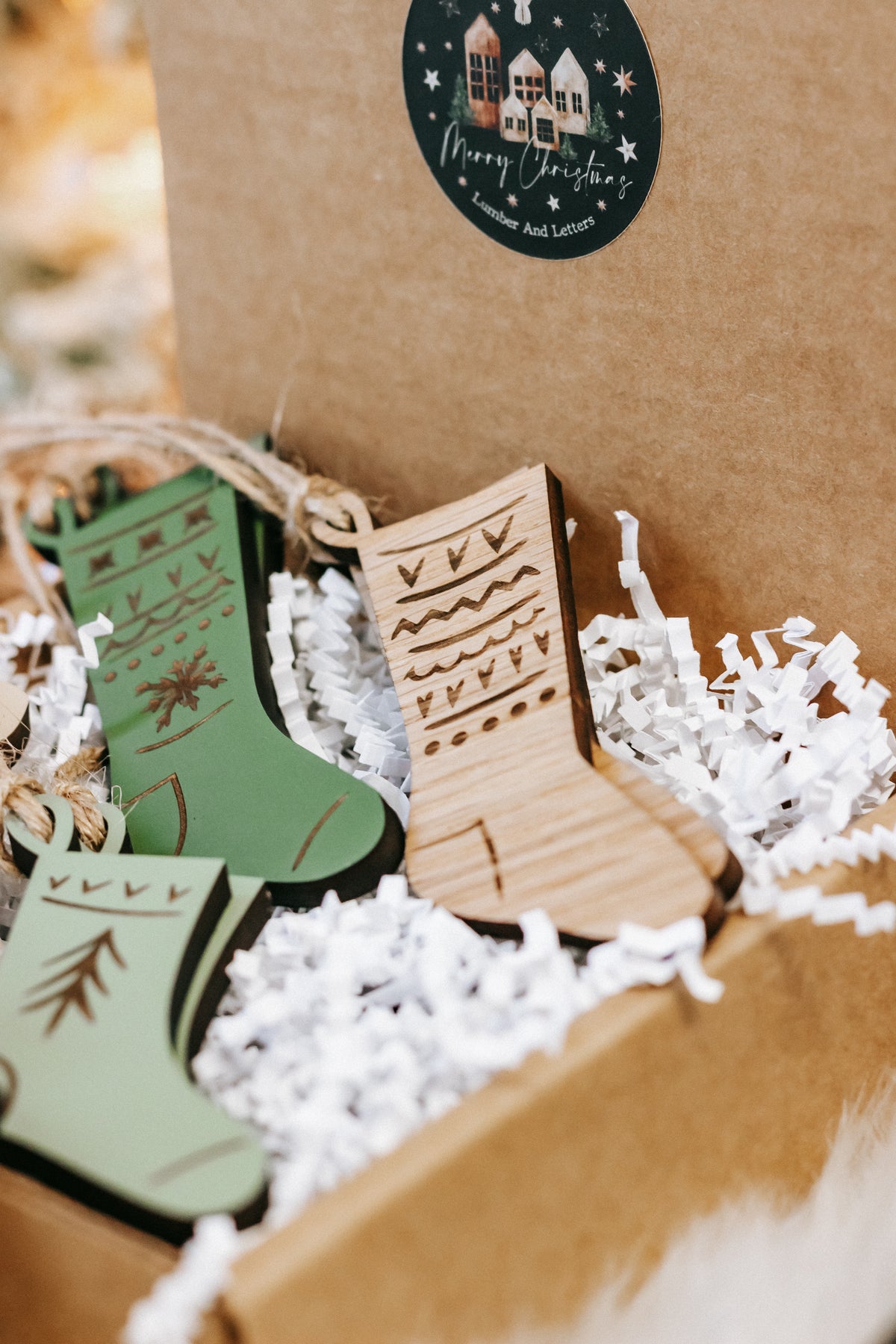 Close-up of engraved wooden stocking ornaments in green and wood tones with holiday motifs