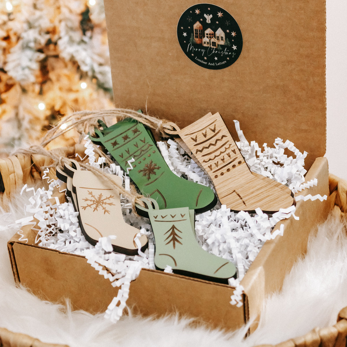 Engraved wooden stocking ornaments arranged in a kraft box with white paper and twine