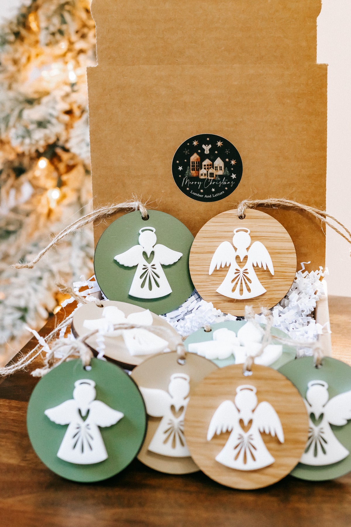 Grouped layered angel ornaments on twine, green and wood round tags with cutout angels