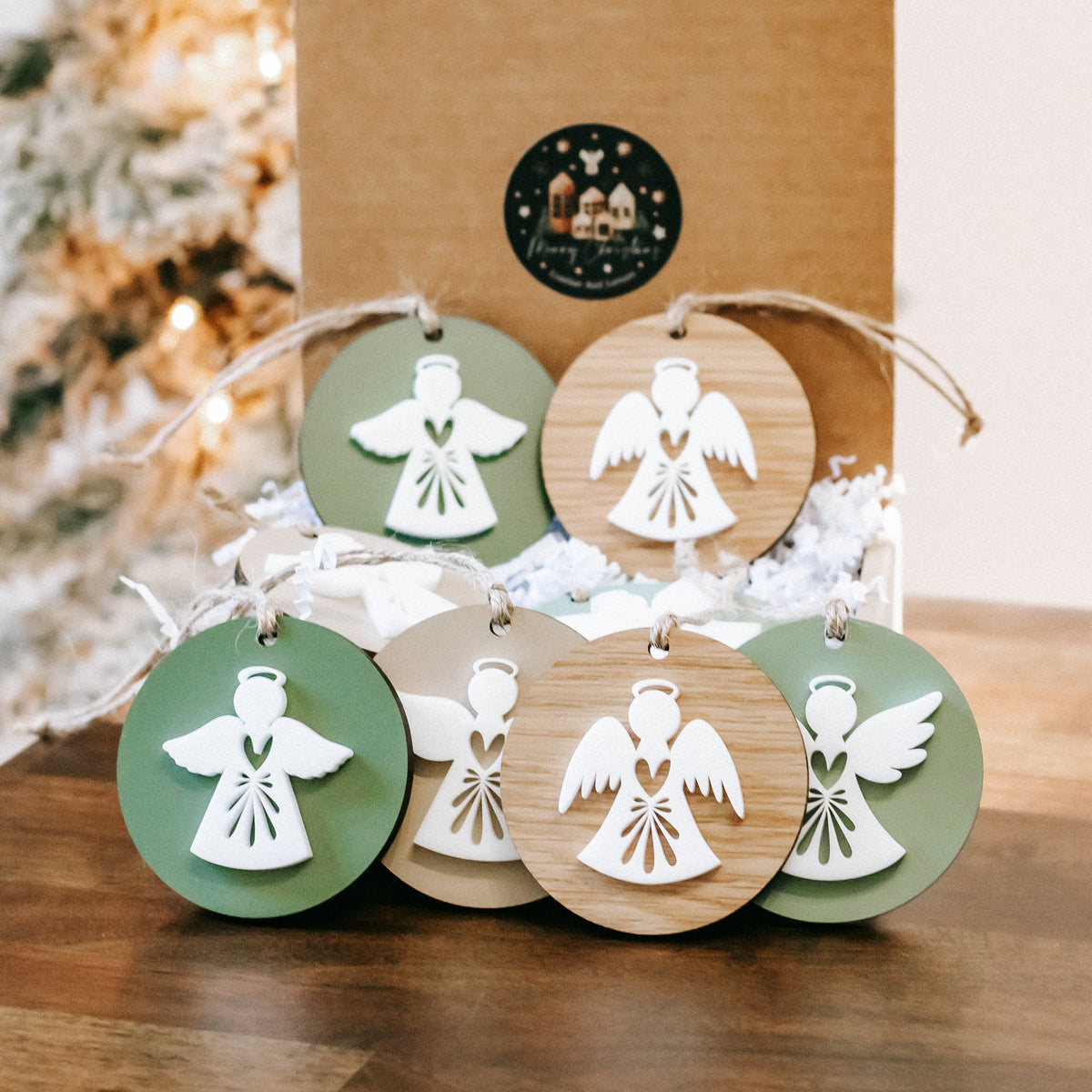 Layered angel ornaments arranged together, green and wood round discs with hanging loops