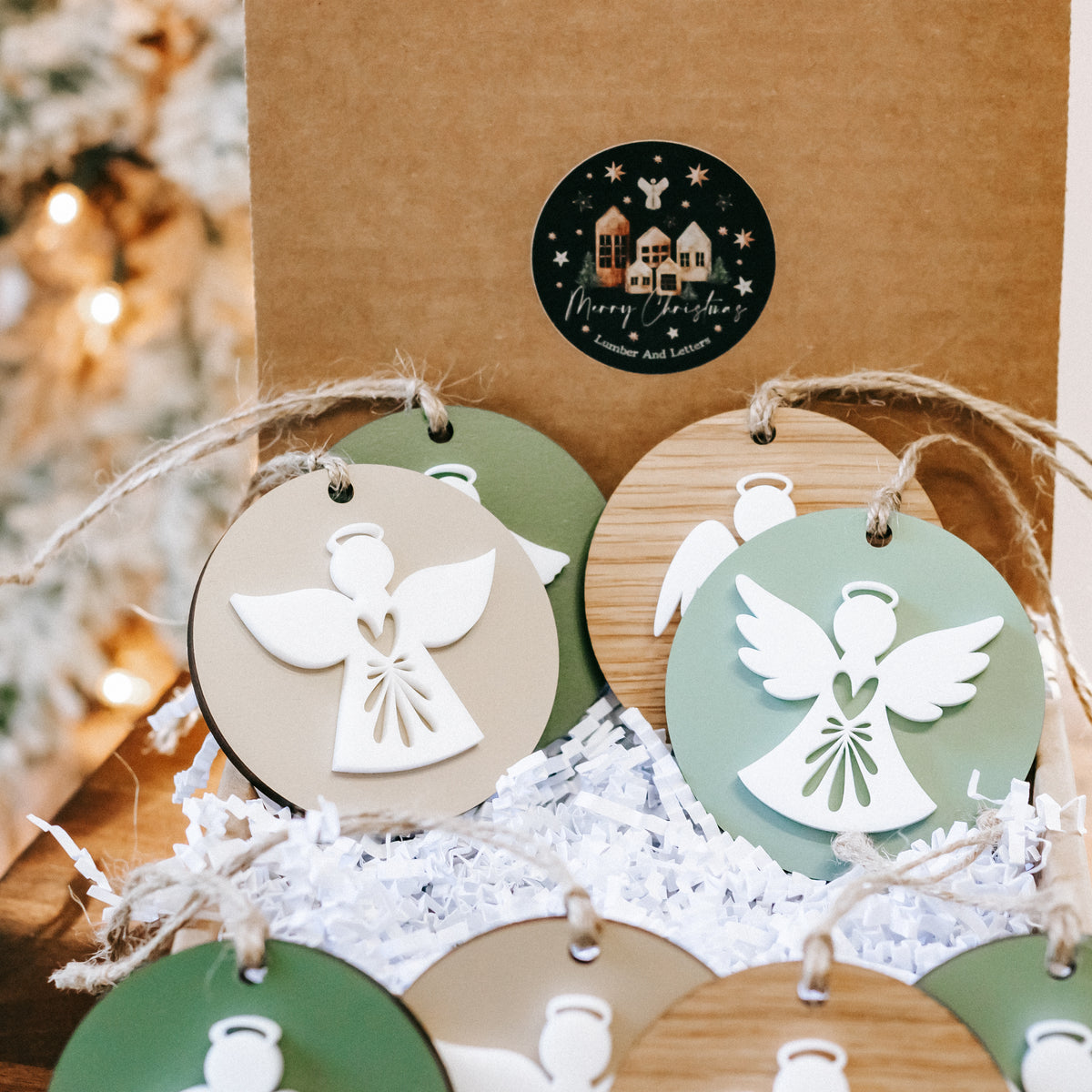 Two layered angel ornaments on twine cords, green and white angel silhouettes on discs