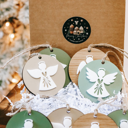 Two layered angel ornaments on twine cords, green and white angel silhouettes on discs