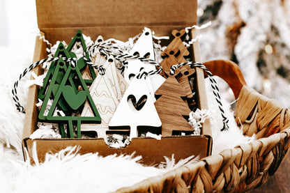 Wooden Christmas ornament box with green tree, white triangle, and heart designs, twine hangers