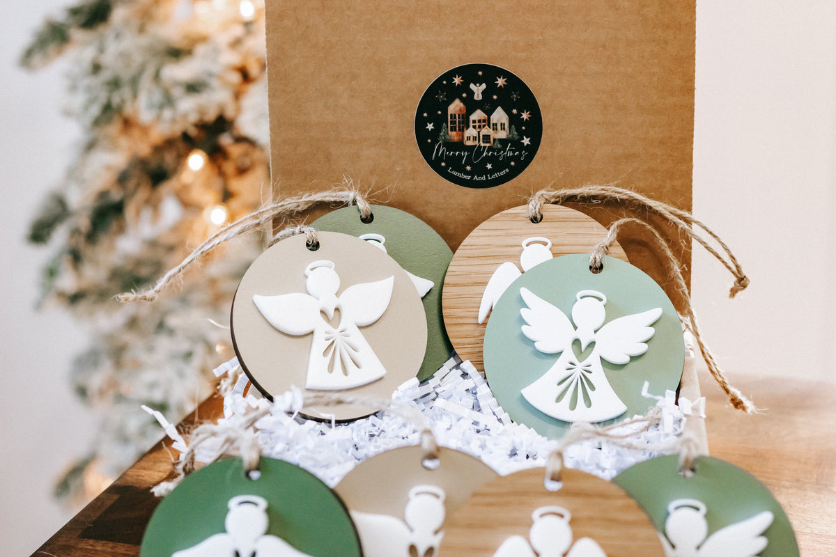 Layered angel ornaments on twine, green and wood round discs with white angel cutouts