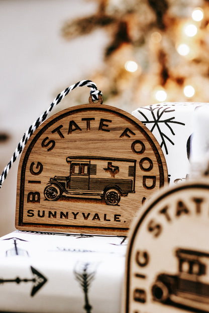 Wooden logo ornament with ribbon hanger; van design and “Sunnyvale, TX” text visible.
