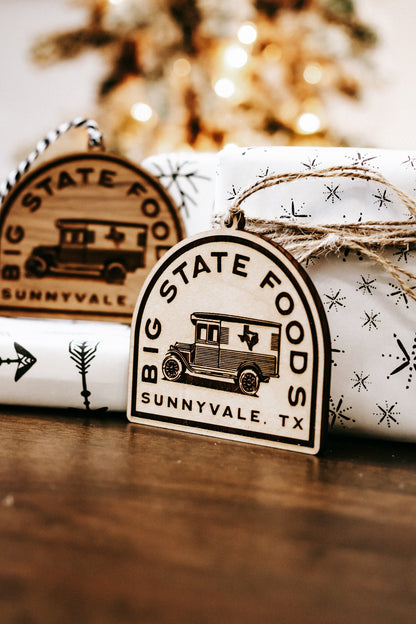 Wood state logo ornament with hanging twine and engraved bus graphic