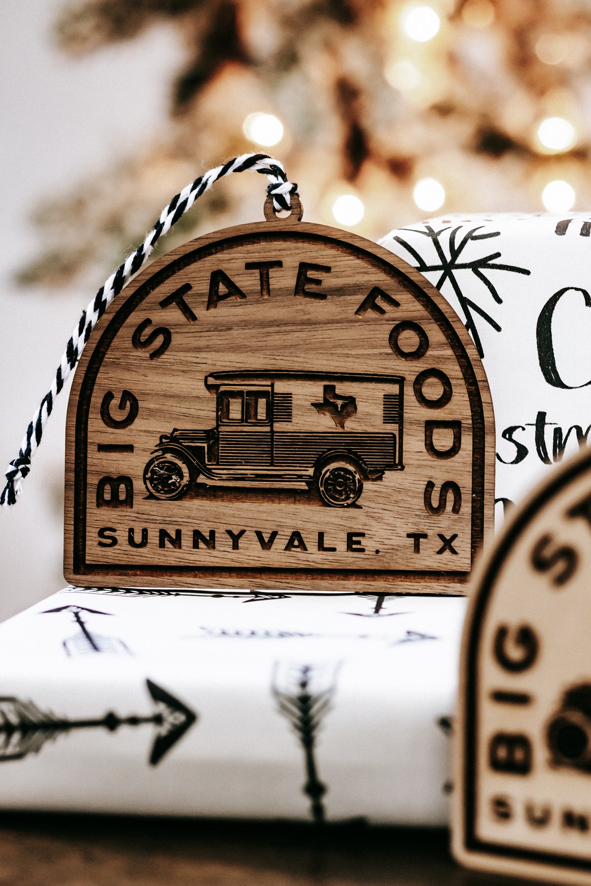 Wood state logo ornament, arched badge with bus engraving and twine loop