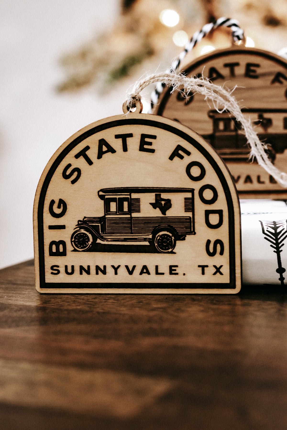 Wooden hanging ornament showing van illustration and “Big State Foods, Sunnyvale, TX” lettering.