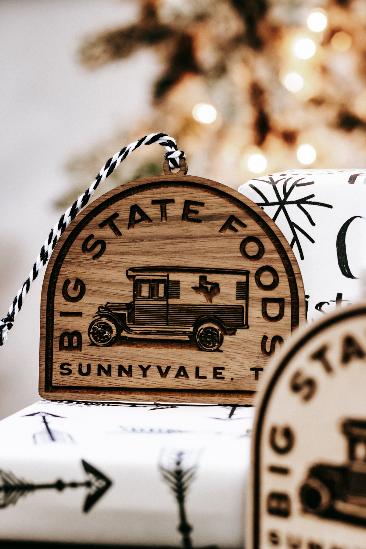 Close-up wooden ornament with painted van graphic and “Big State Foods / Sunnyvale, TX”.