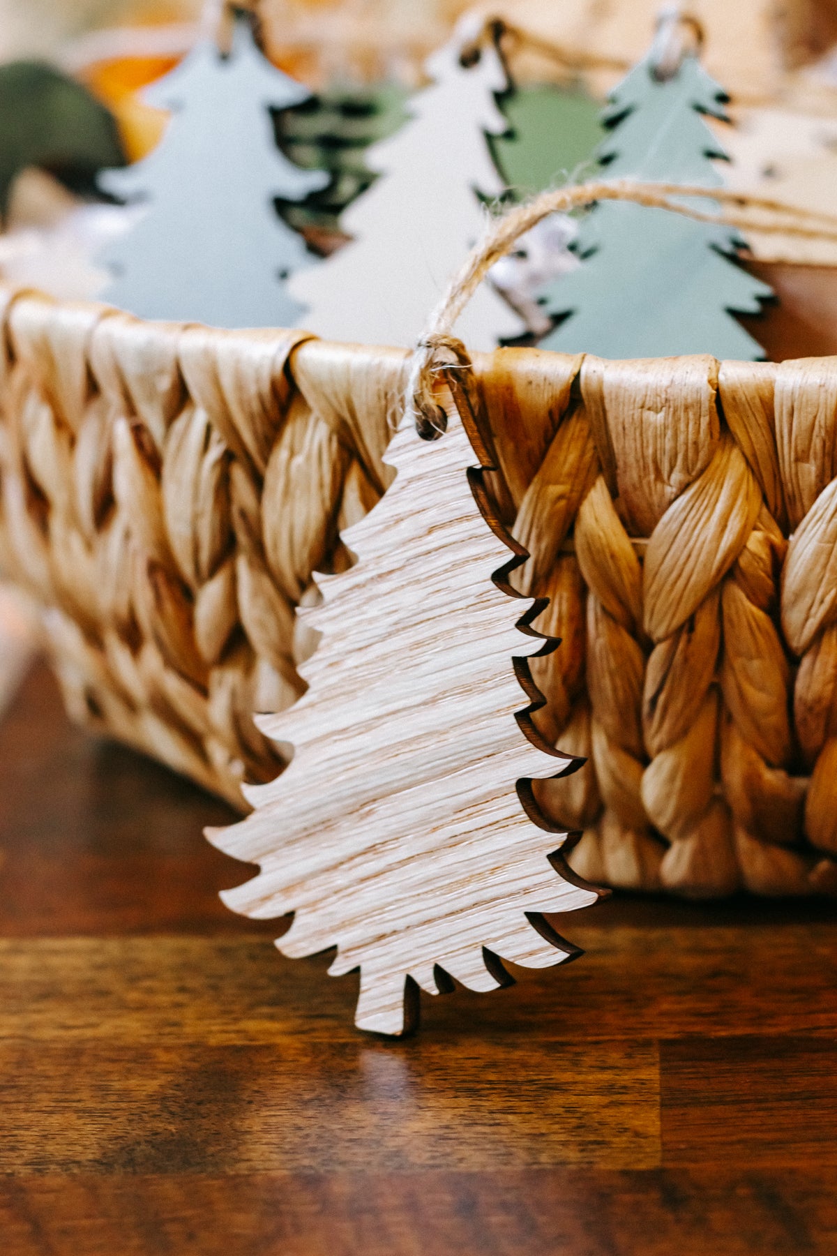 Close-up of wooden Christmas tree ornament with twine loop on woven basket