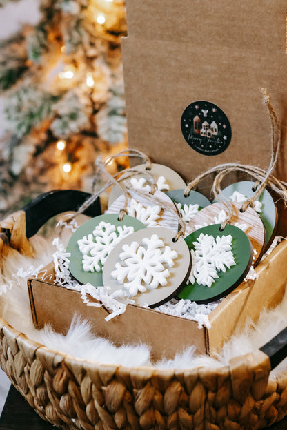 Wooden round snowflake ornaments with dark green and wood bases, white cutouts, twine hangers