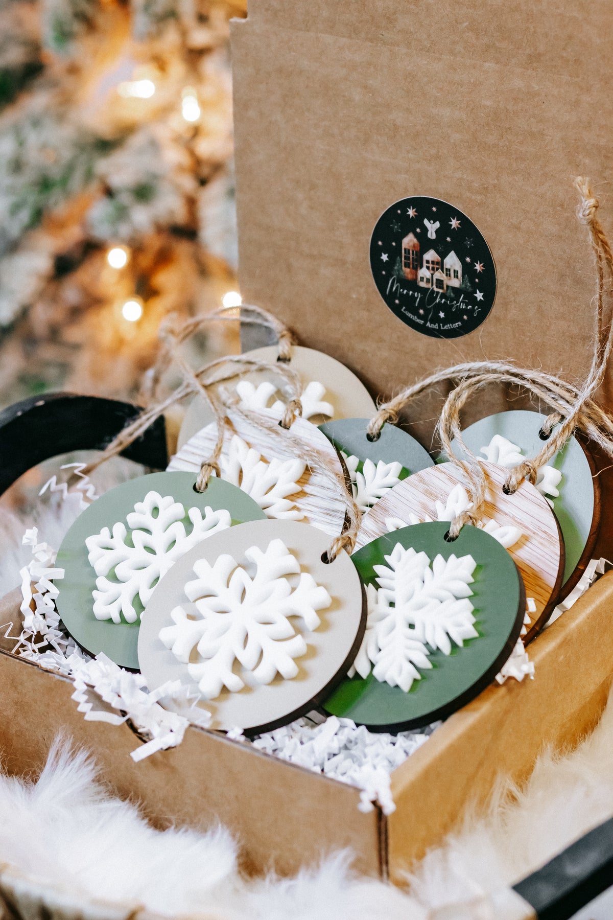 Layered wooden snowflake ornaments with green and black discs, hanging on twine