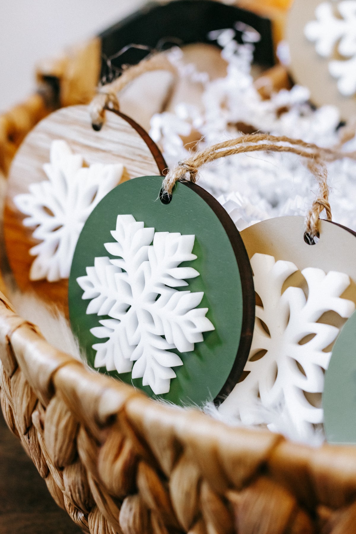Round snowflake ornament with green disc and white carved snowflake, twine hanger