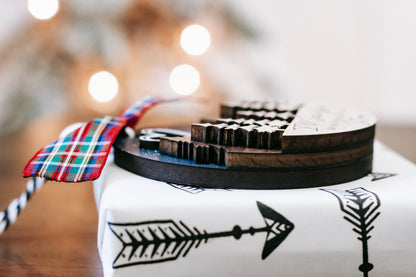 Memorial Christmas ornament close-up with plaid ribbon bow and arrow pattern on base.