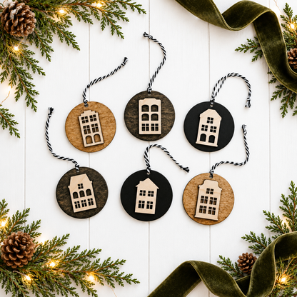 Round wooden house ornaments with cutout windows, hanging on striped twine cords