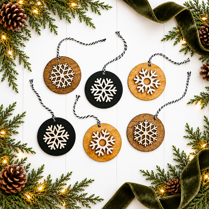 Set of hanging round snowflake ornaments in light wood and black with white cutout snowflakes
