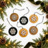 Set of hanging round snowflake ornaments in light wood and black with white cutout snowflakes