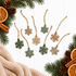 Hanging mini wooden snowflake ornaments with natural wood and green painted details.