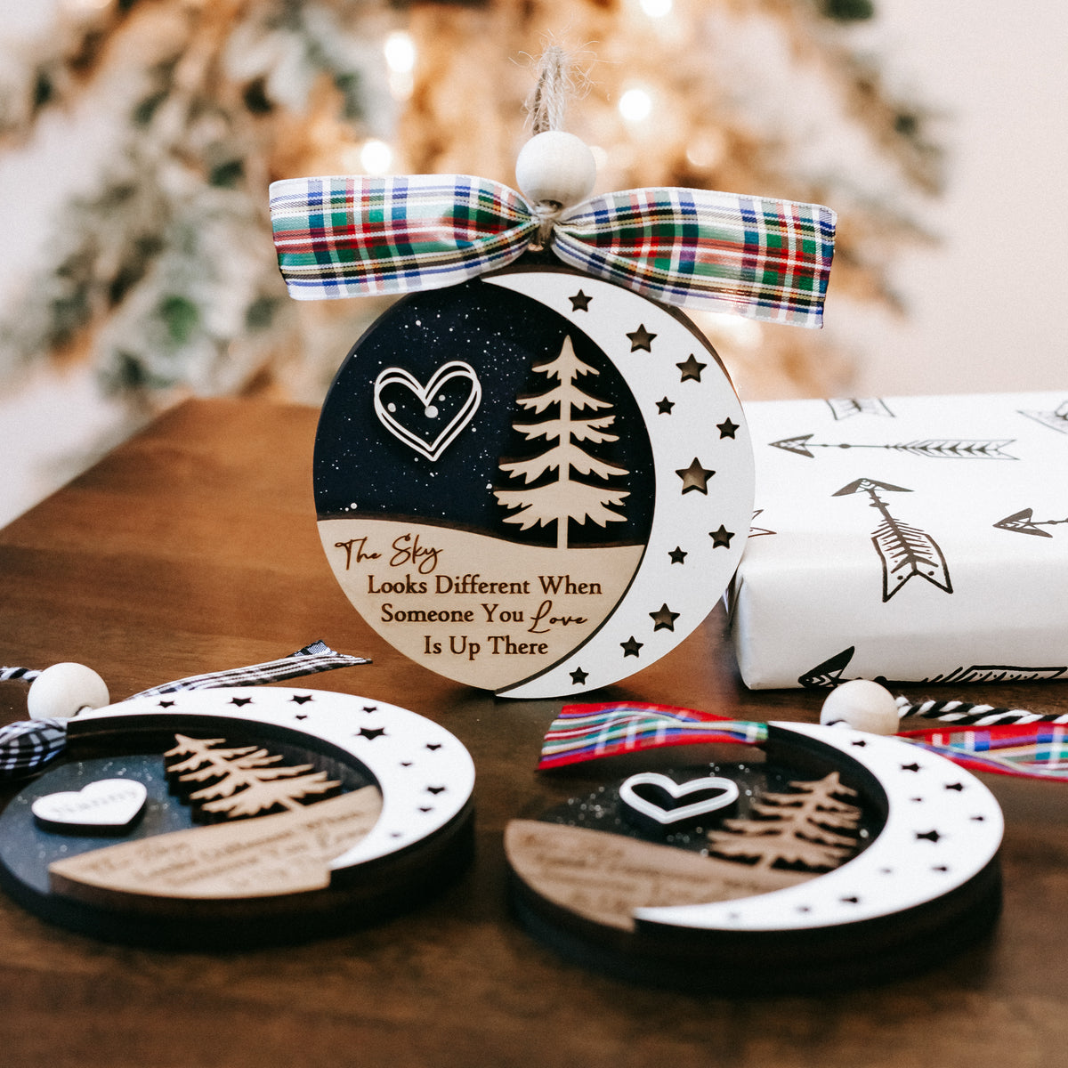 Round memorial ornament set with plaid bows, heart and tree designs, star details.