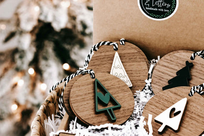 Close-up set of wooden Christmas ornaments on striped string hangers, tree and star shapes