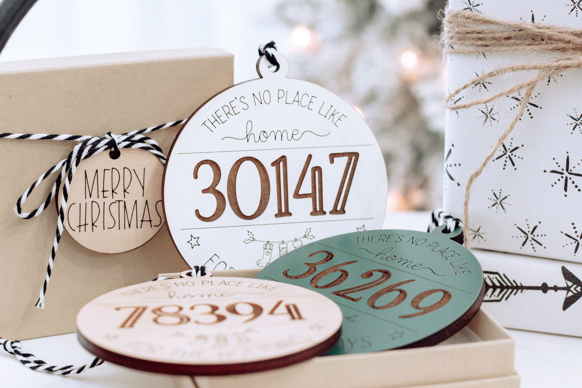 Round personalized home holiday ornament with “30147” in red on white wood.