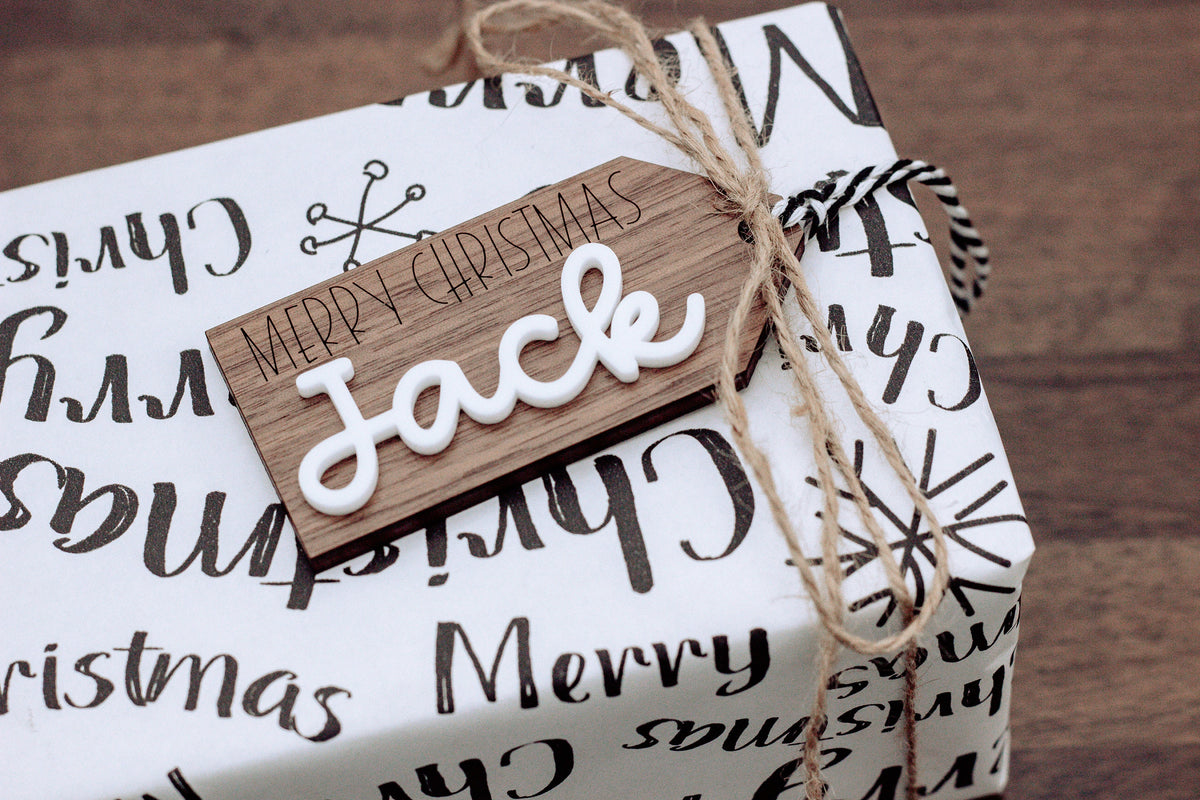Wood gift tag with “Face” lettering and Merry Christmas text, tied with twine