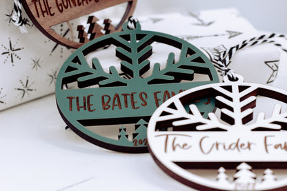 Green and dark wood engraved family name ornaments with tree cutouts and hanging loops